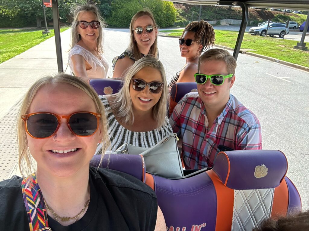 Photo of 6 members of the BASC team sitting in a Clemson golf cart